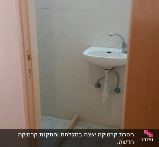 כיור מותקן בחדר אמבטיה עם אריחים לבנים